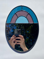 Stained glass decorative mirror with a muted arch design.